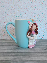 Load image into Gallery viewer, Handmade Polymer Clay 3D Girl in White Unicorn PJs on a Blue Ceramic Mug
